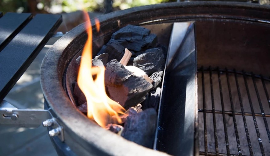 This image shows burning charcoals in a Slow 'N Sear Original Charcoal Basket