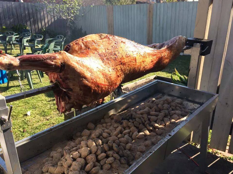 Large spit roaster cooking a whole lamb