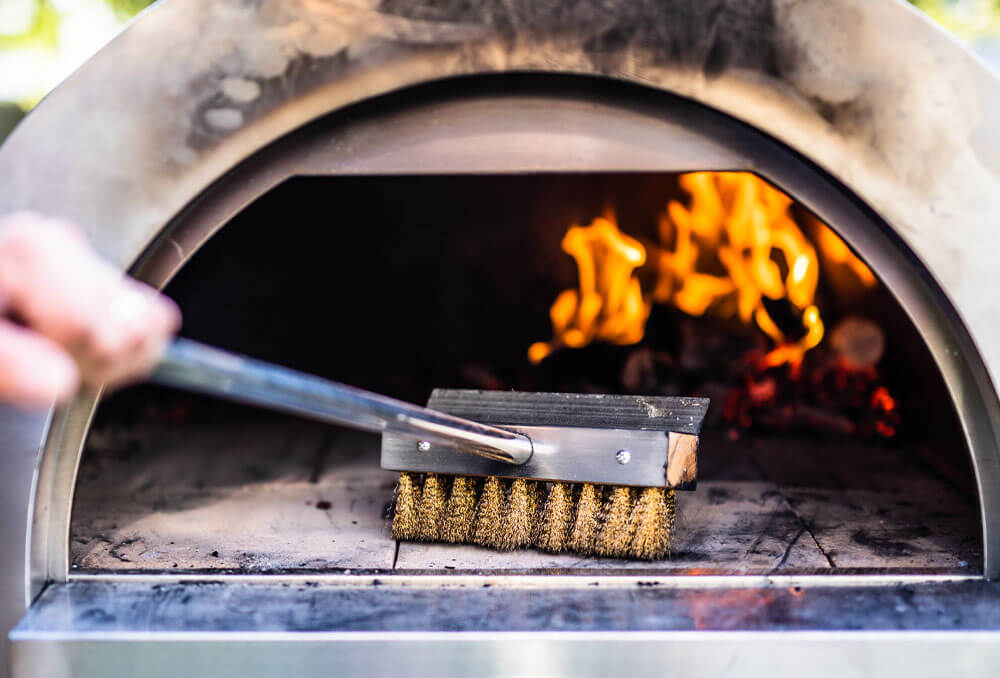 This image shows a brush to push the fire to the back of the oven