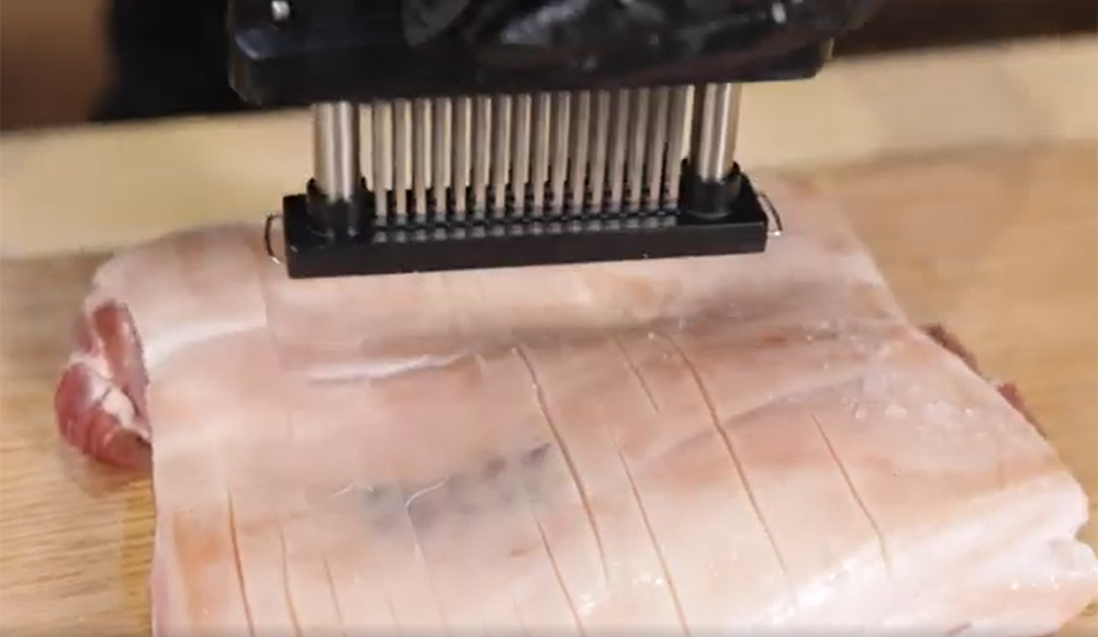 This_image_shows_a_Pork_Belly_being_scored_using_a_jaccard