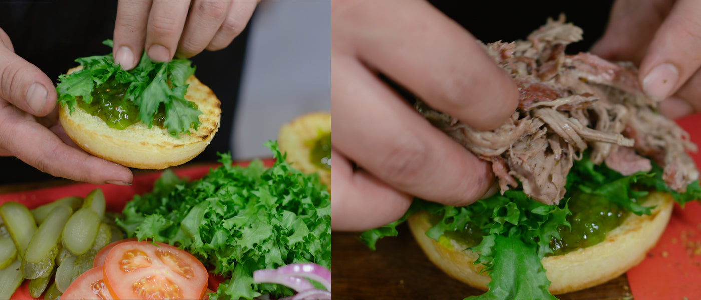 THis image shows a man assembling the bun with lettuce and pulled lamb