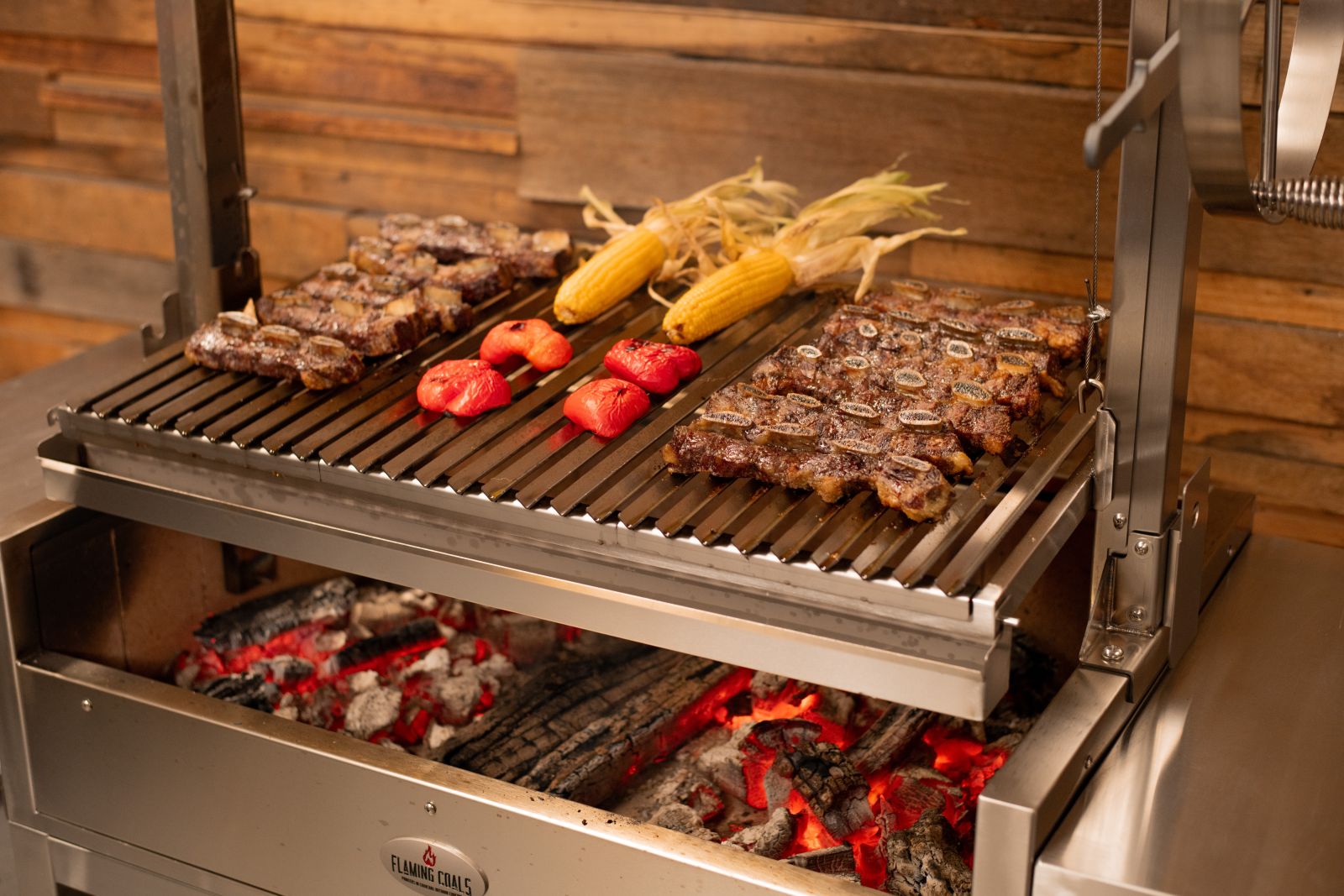 Parrilla grill cooking steaks, corn and vegetables over live charcoal fire