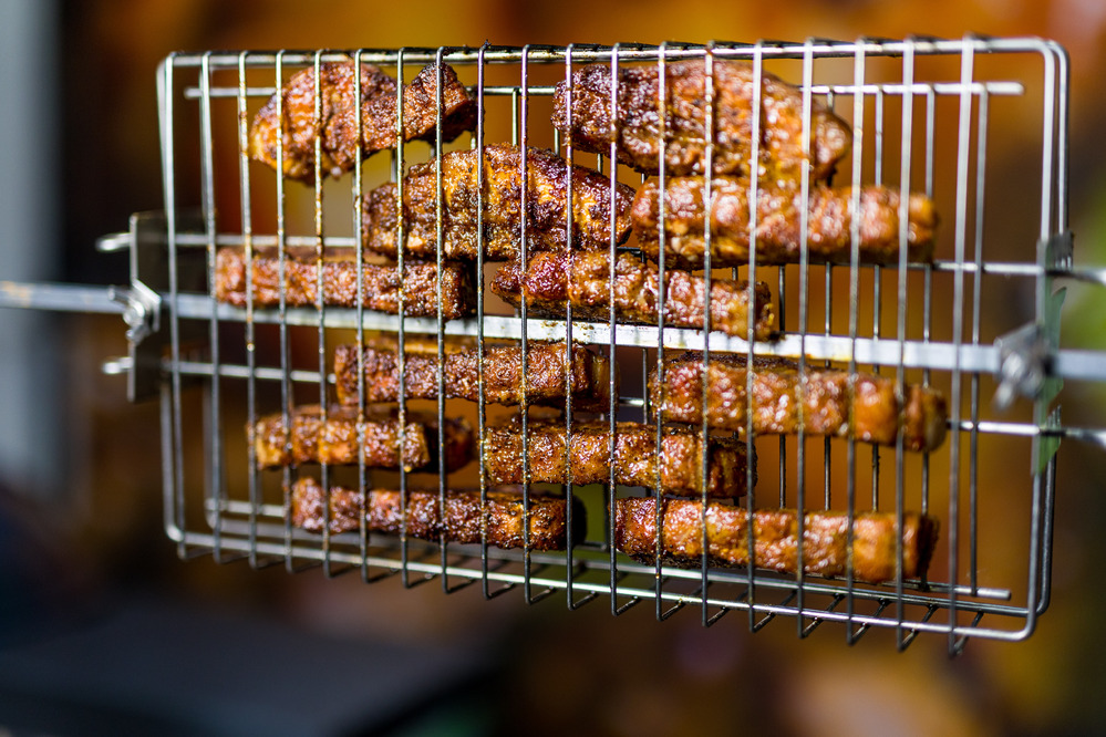 Crispy pork belly bites roasting in the Flaming Coals multi-use rotisserie basket, delivering perfect char and smoky BBQ flavour.