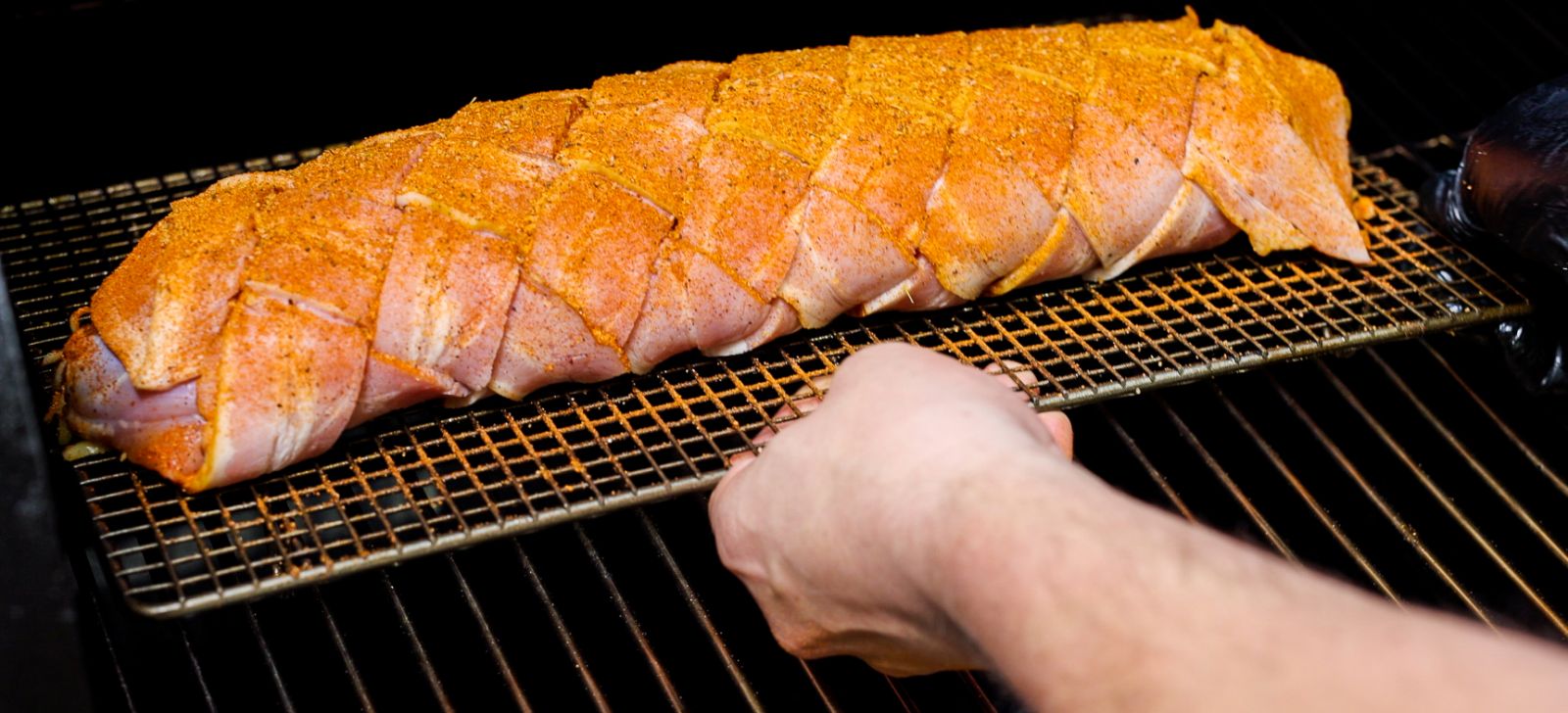 this image shows the bacon chicken fatty placed on an offset smoker. 