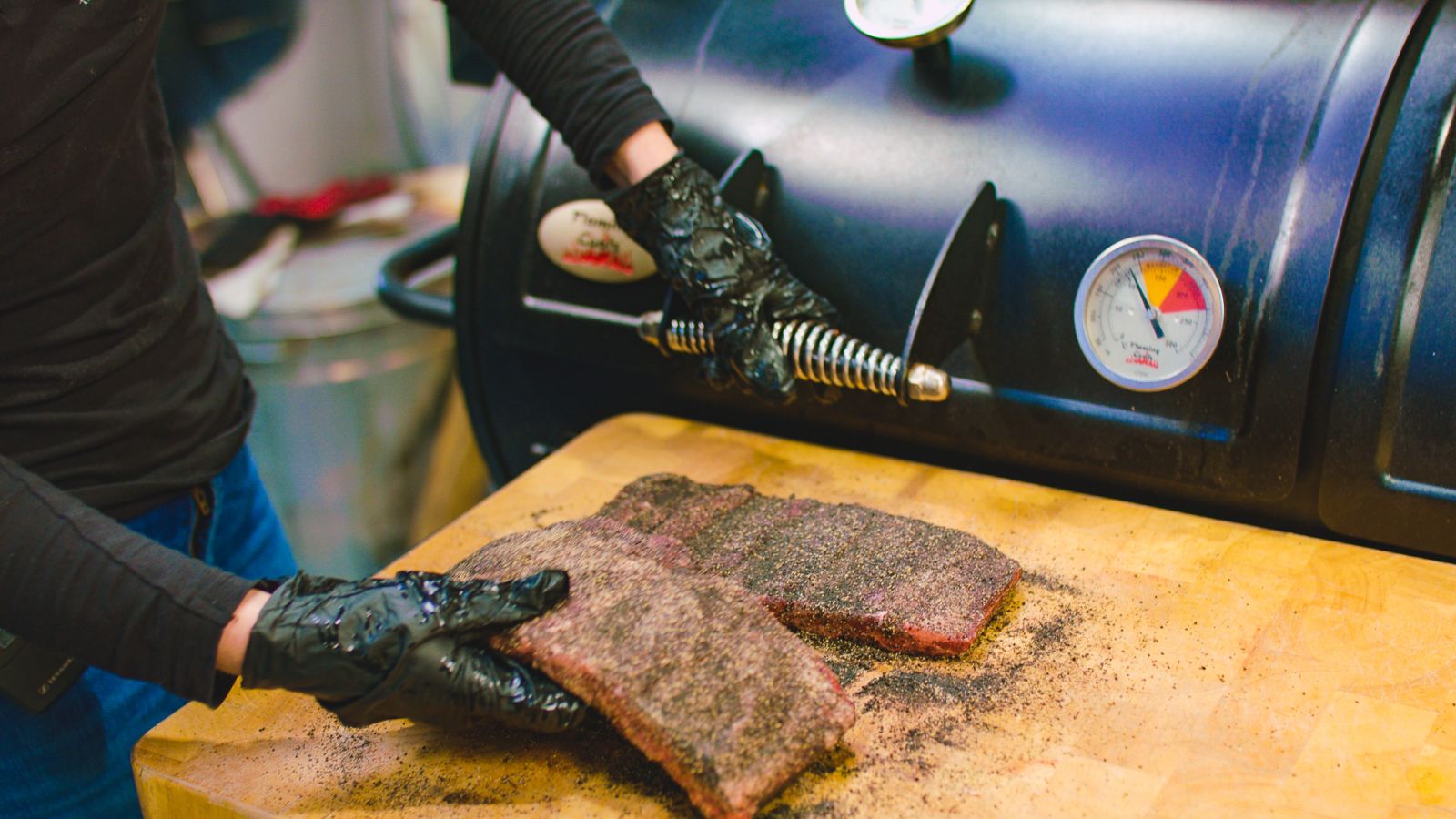 This image shows the beef ribs are being placed in the Offset Smoker
