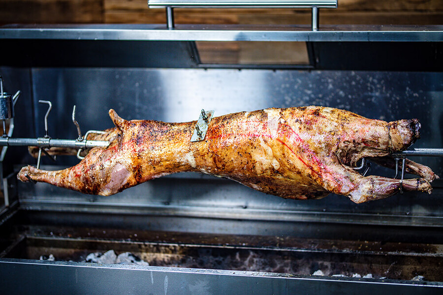 This_image_shows_whole_lamb_being_cooked_on_spit_rotisserie