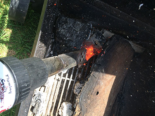 In this picture you will see a charcoal starter wand being used to light the fire in an Offset Smoker
