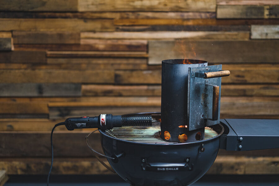 This_image_shows_charcoal_chimney_with_lit_charcoal_and_charcoal_starter_wand