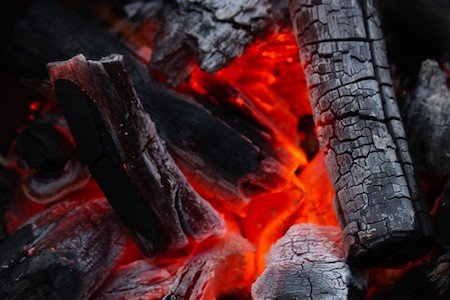 This image show the flaming coals lump BBq charcoal that is a charcoal for BBQ, burning red hot