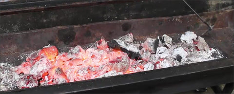 This_image_shows_hot_charcoal_in_a_spit_roaster
