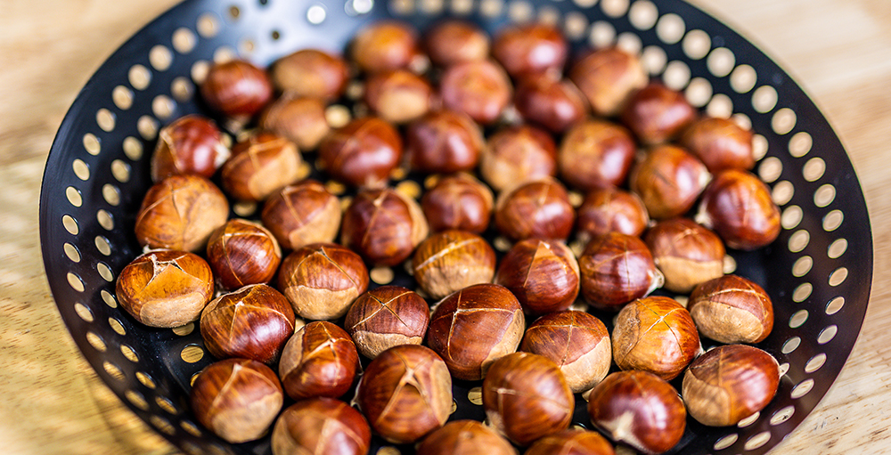 This image shows chestnuts on Flaming Coals Chestnuts roaster Skillet