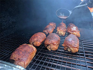 This picture shows Chicken thighs inside an offset smoker