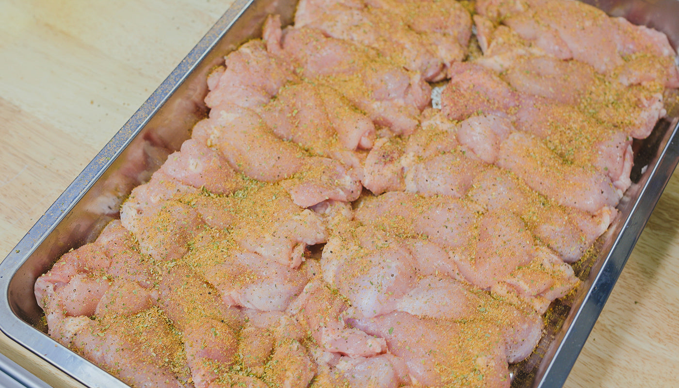 This image shows chicken thighs seasoned with Flaming Coals Greek Gyros Rub