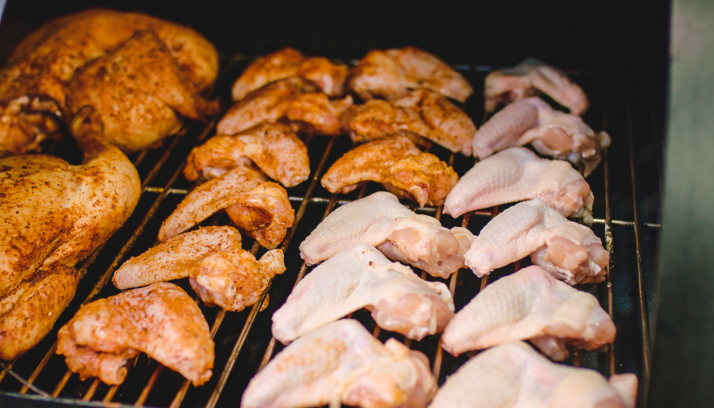 This image shows Chicken Wings being cooked in an offset smoker