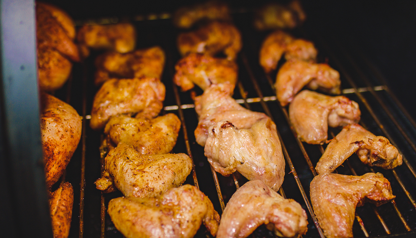 This image shows chicken wings in a offset smoker