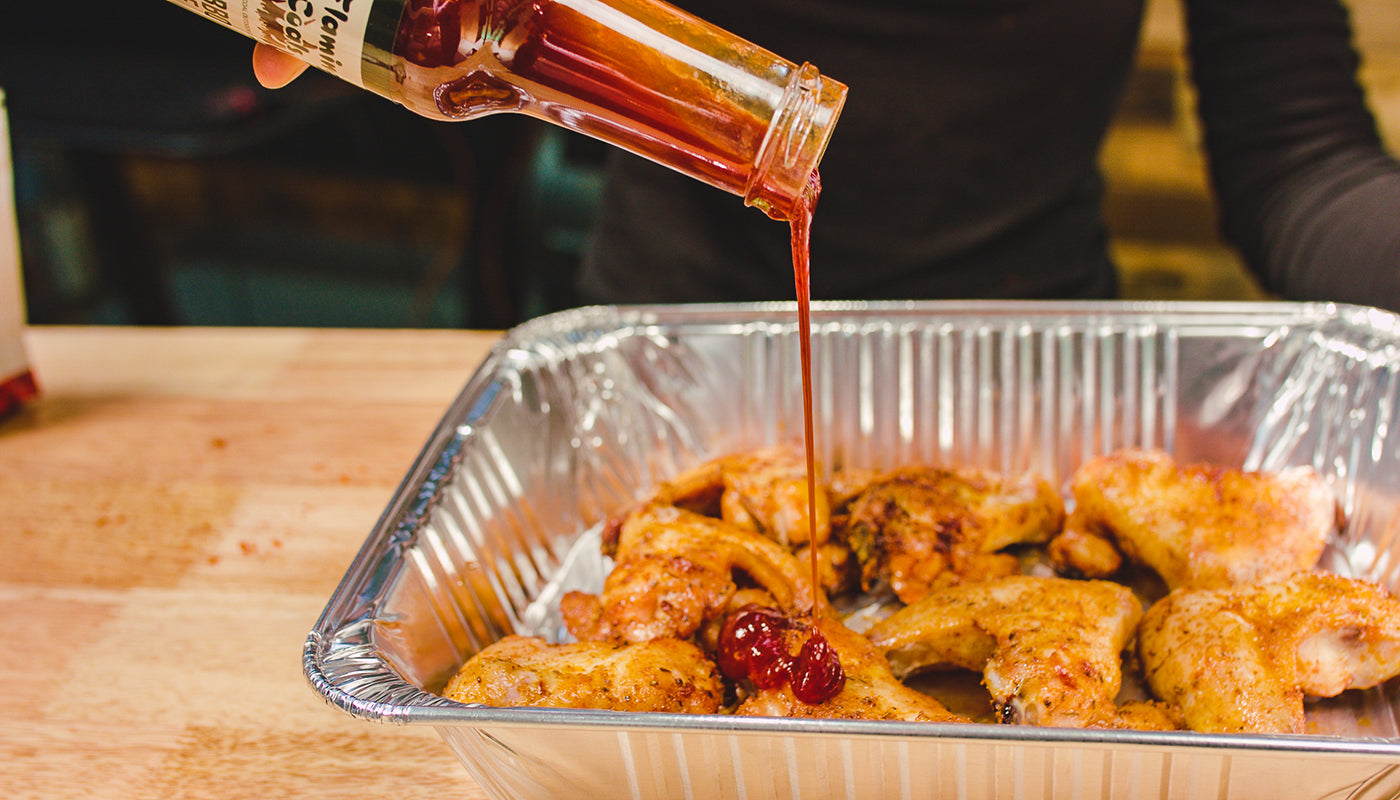 This image shows chicken wings with Flaming coals Hot Bbq Sauce