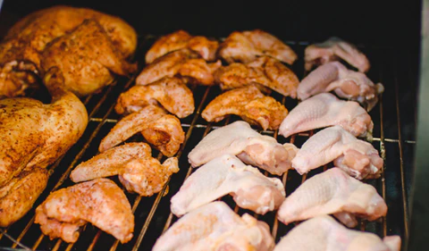 This_image_shows-Chicken_wings_being_cooked_on_offset_smoker