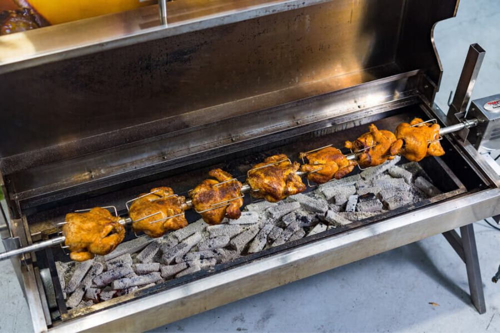 This image shows whole chicken cooked on Charcoal Spit Roaster