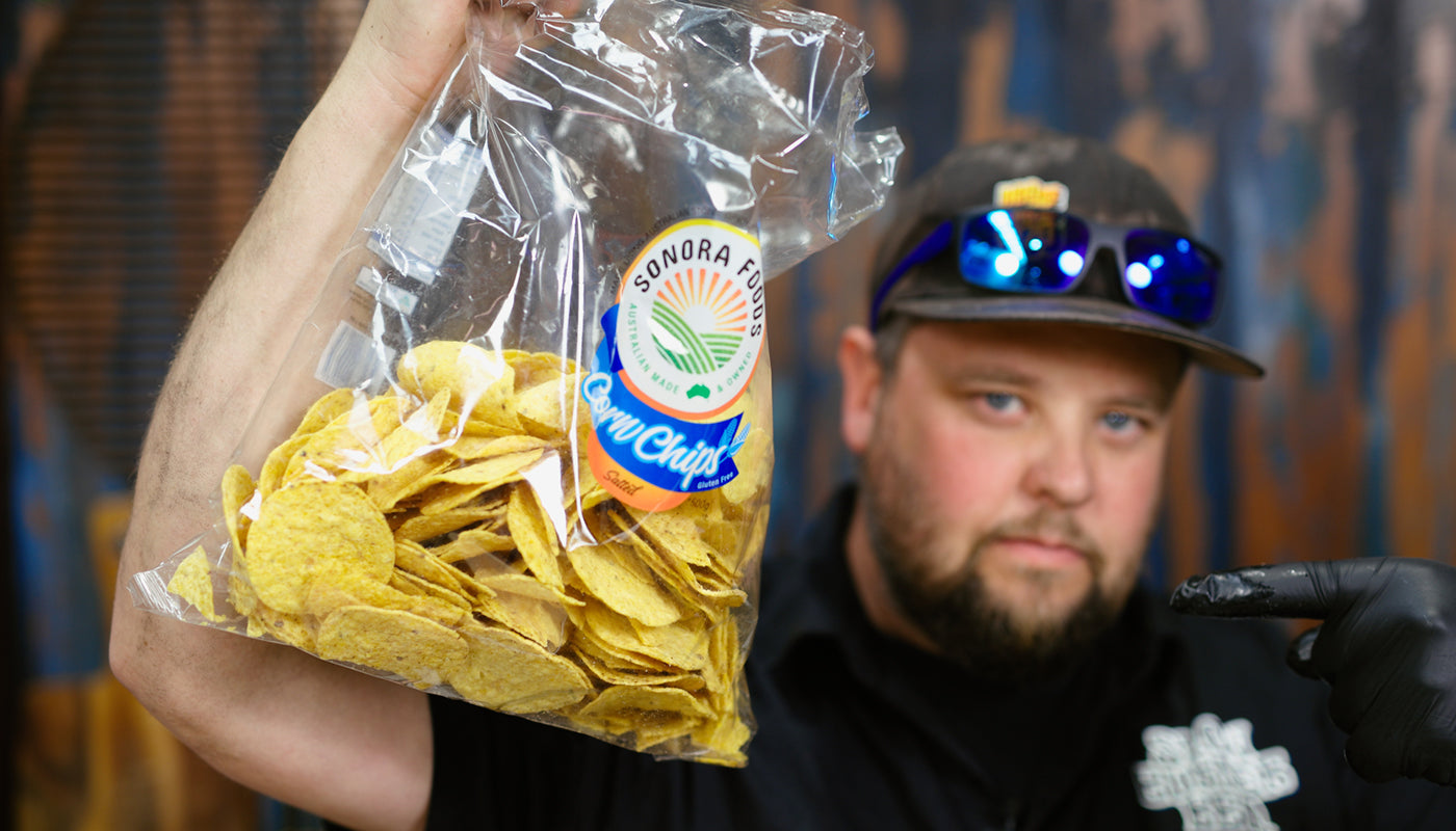 This image shows Westy from Slow Burner Barbeque holding the chips  an ingredients for Nachos