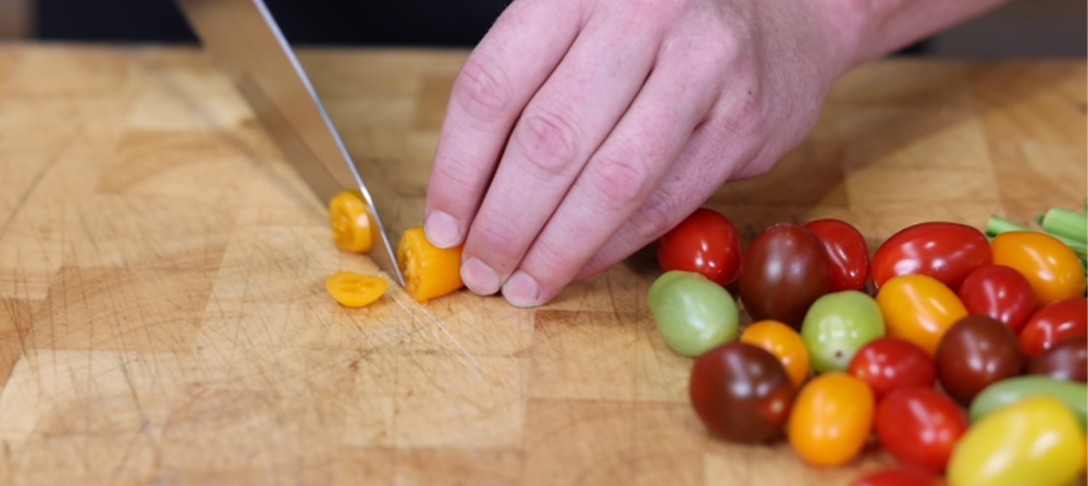This_image_shows_cherry_tomatoes_being_chopped