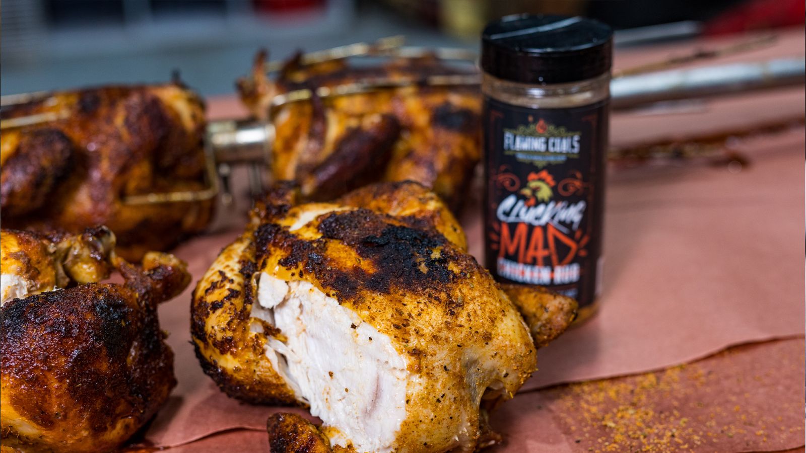This image shows cooked chickens and Flaming Coals Chicken rub on the side