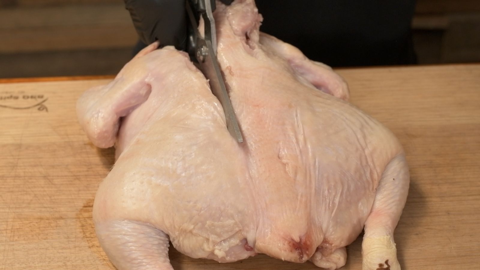 This_image_shows_a_chicken_with_its_spine_being_removed