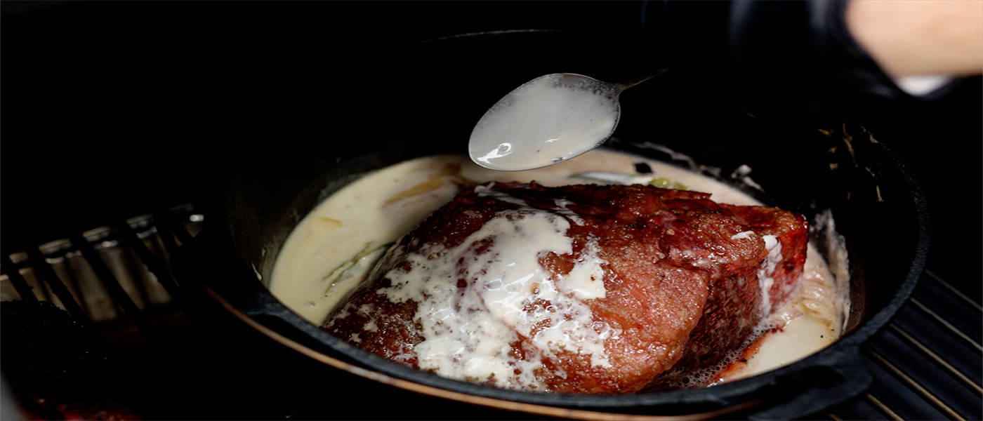 This image shows the Flaming coals dutch oven with rump cap placed on offset smoker