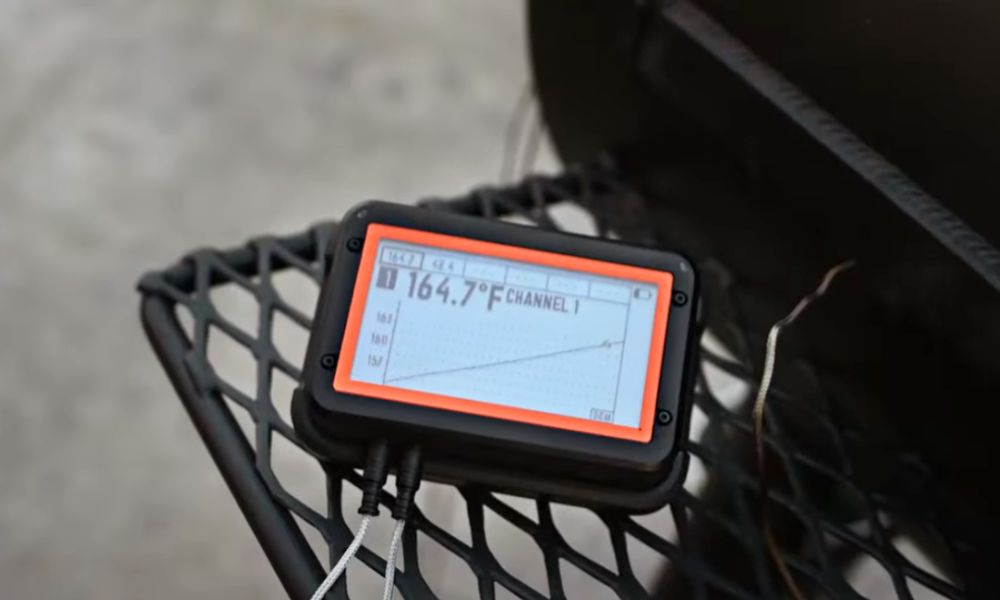 Fireboard Pro thermometer mounted on magnetic stand showing live temperature reading on barbecue smoker