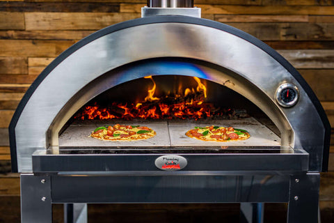 Pizzas cooking inside a wood fired pizza oven with stone base
