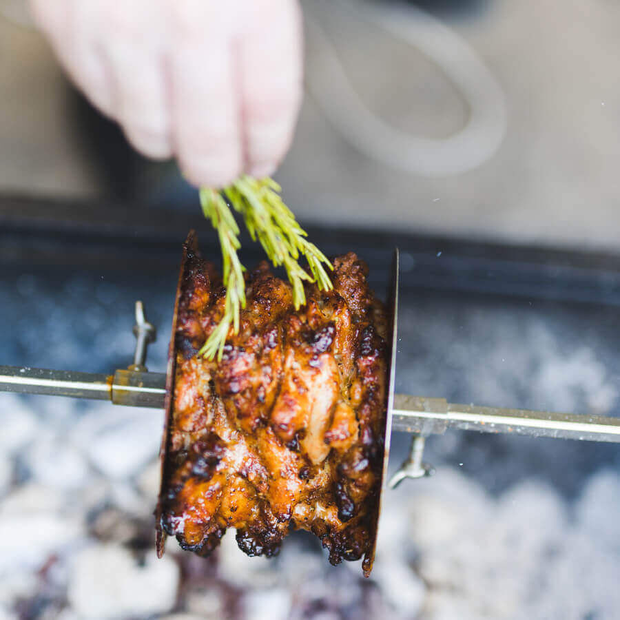 Gyros meat cooking on rotisserie using stainless steel gyros disc over charcoal