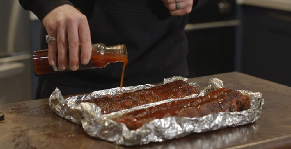 This_image_shows_pork_ribs_being_seasoned_with_Boomas_Sauce