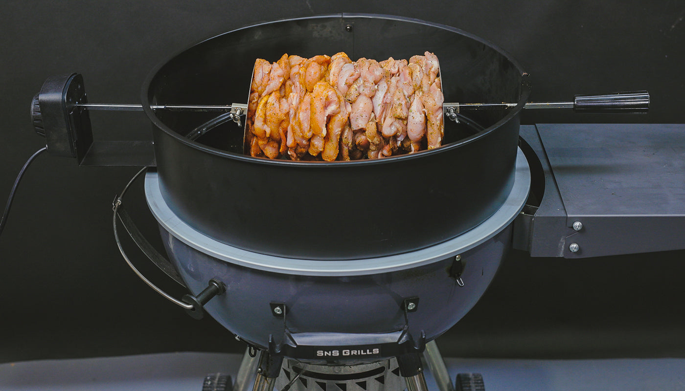 The image  shows a gyro being cooked in a 57cm kettle bbq on a kettle rotisserie kit