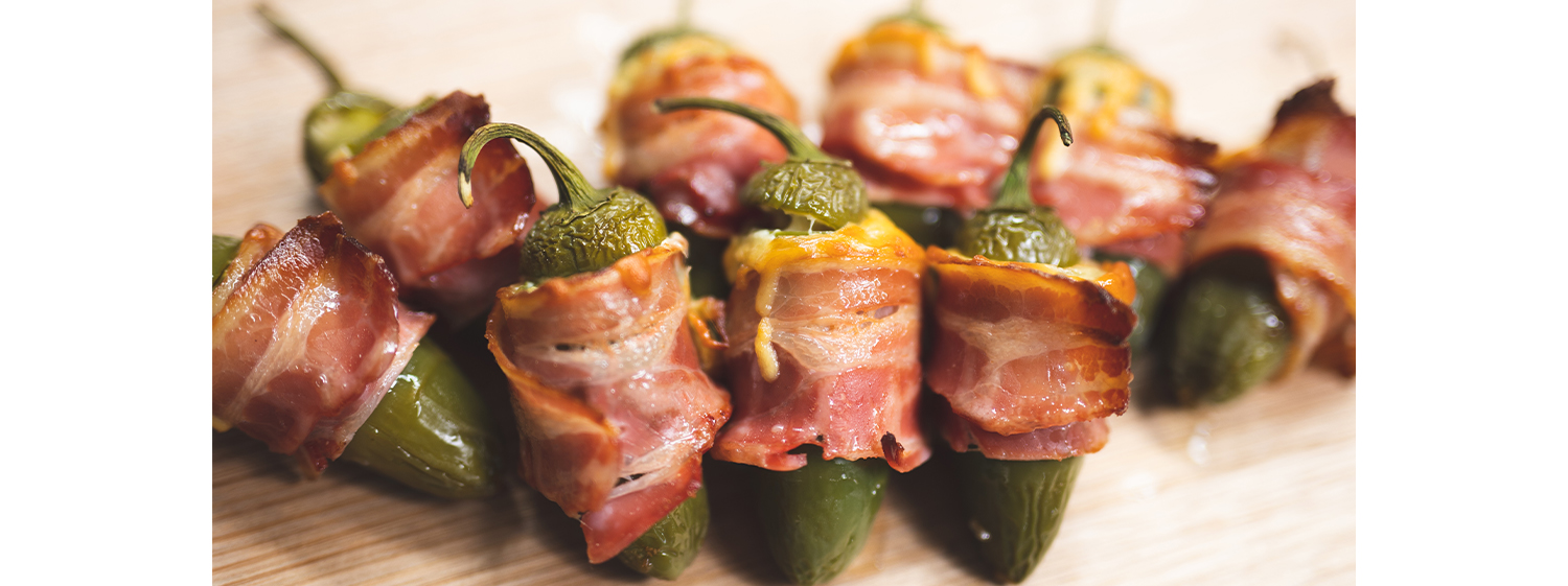 Jalapenos wrapped in bacon stuffed with loads of melted cheese and seasoning