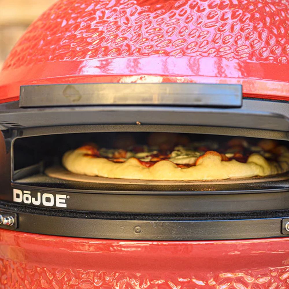 Classic Joe Pizza Oven Attachment with a freshly baked pizza inside, showing the stone and interior of the Kamado Joe oven.
