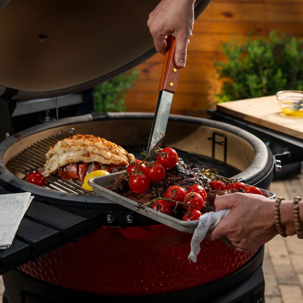 Kamado Joe Konnected Joe digital charcoal grill cooking steak and seafood with tomatoes