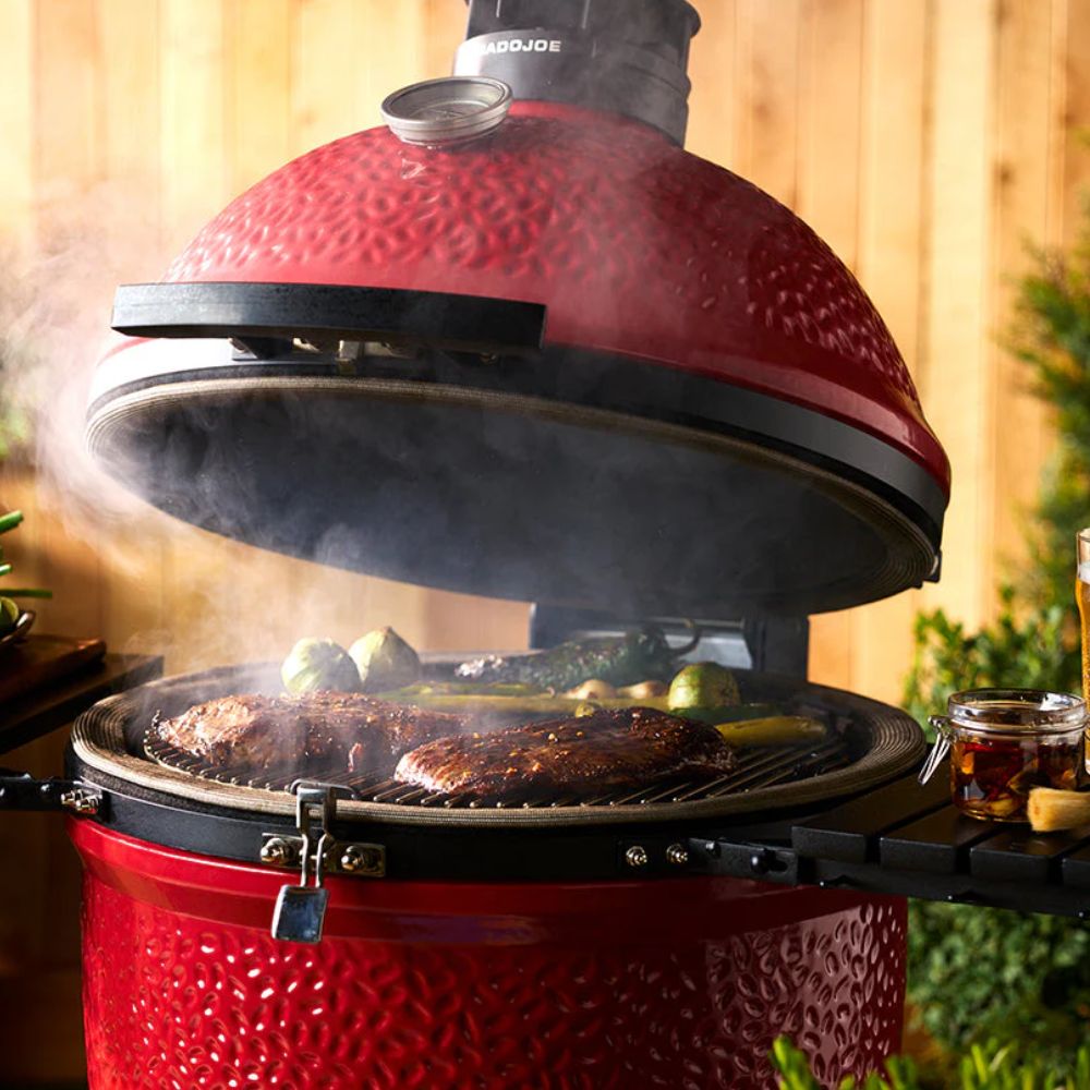 Kamado Joe Classic Joe Series II ceramic grill cooking steak and vegetables over charcoal