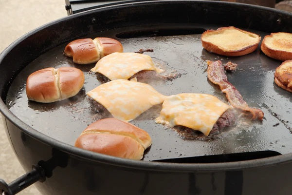 This image show burgers being cooked on a SNS weber kettle hotplate 57cm