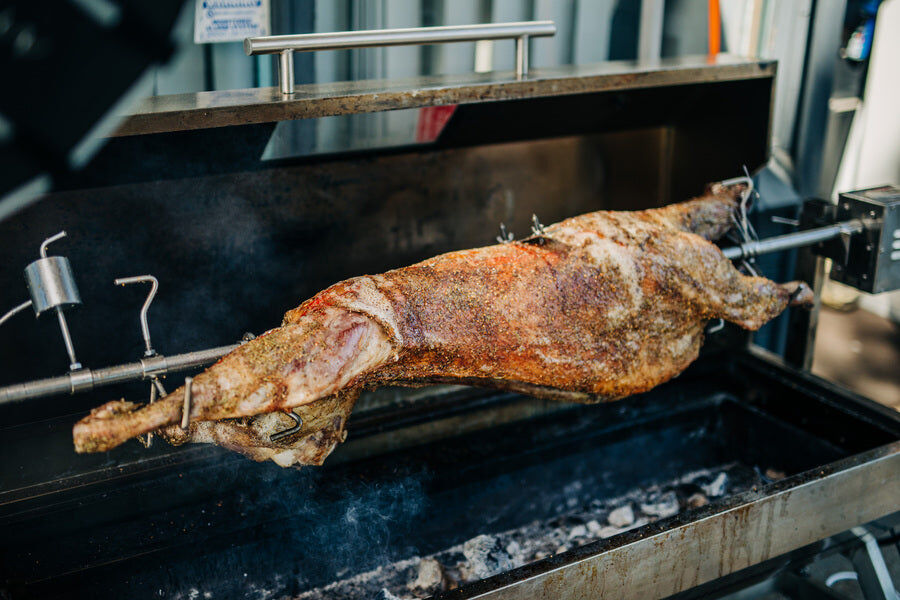 Spit Roast Collar Leg Brace Stainless Steel being used in cooking whole lamb