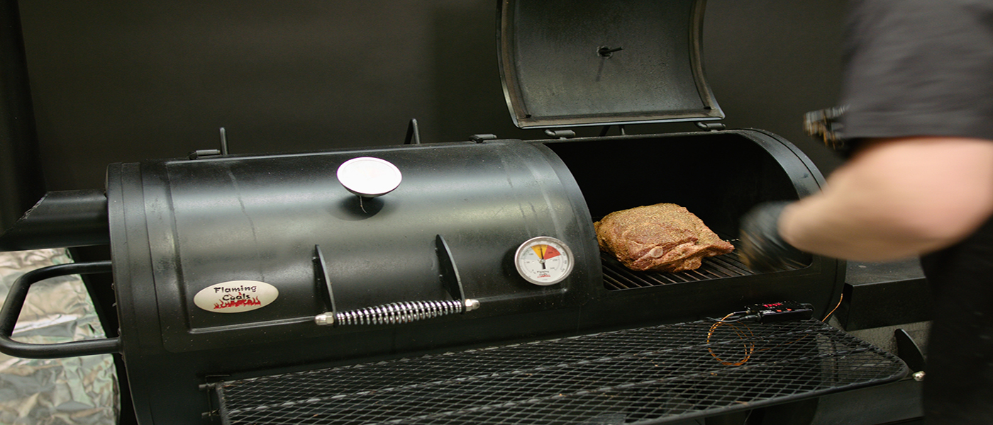 This image shows a lamb shoulder cooked on offset smoker