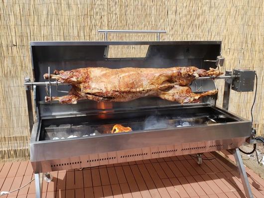 This is a picture of a lamb being cooked on a dual fuel gas spit roaster