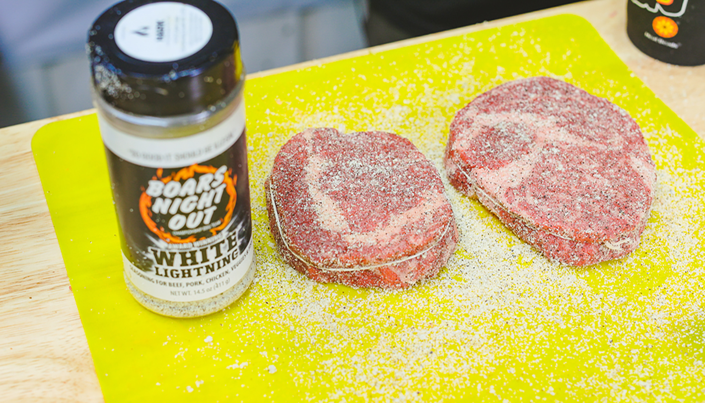 This image shows a steaks seasoned with Boars Night Out White Lightning Rub