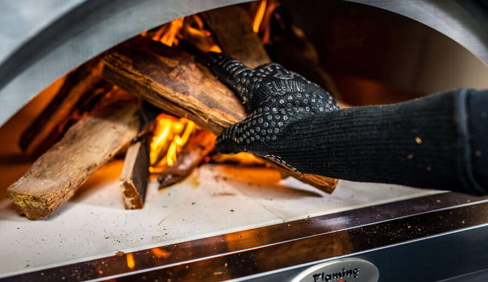 This image shows heat proof gloves used in adding kindling to pizza oven