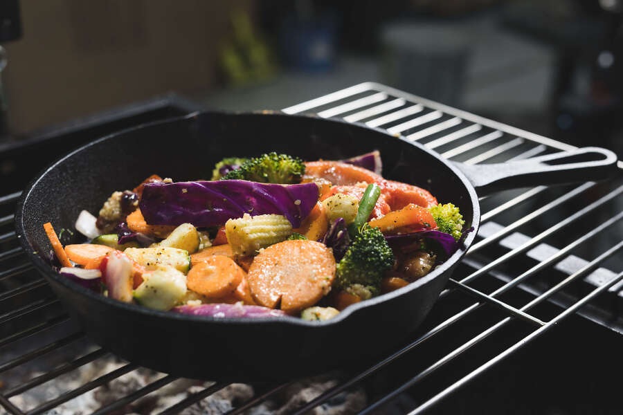 This_image_shows_mixed_veggies_being_cooked_cast_iron_pan
