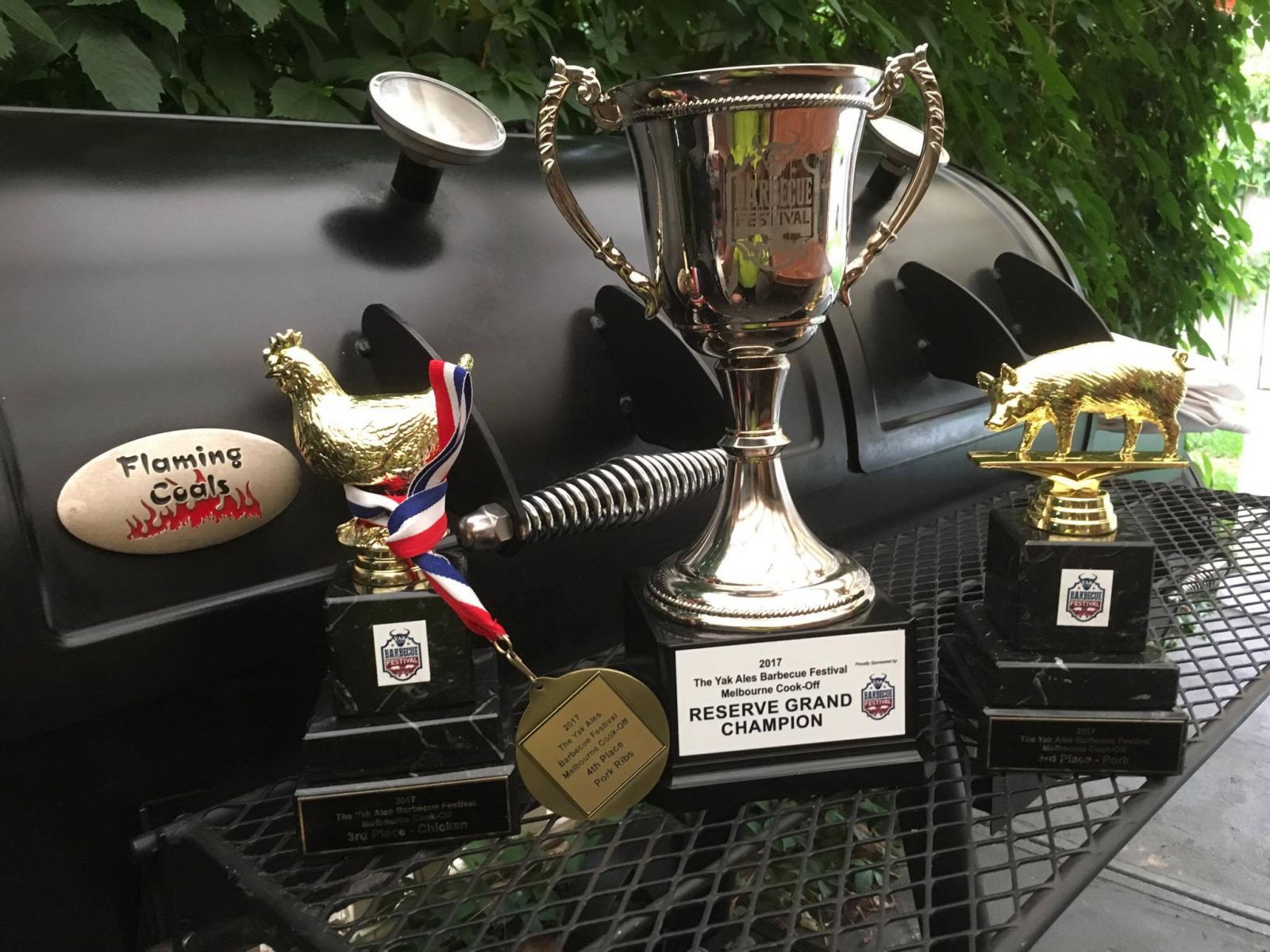 Picture showing some of the trophies won by competition teams using the flaming coals offset smoker in Australia