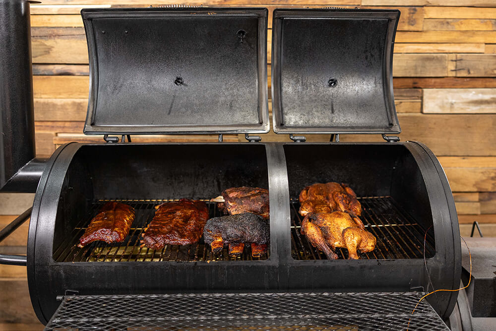 This_image_shows_Offset_smoker_with_pork_ribs_beef_ribs_lamb_shoulders_and_wjole_chickens