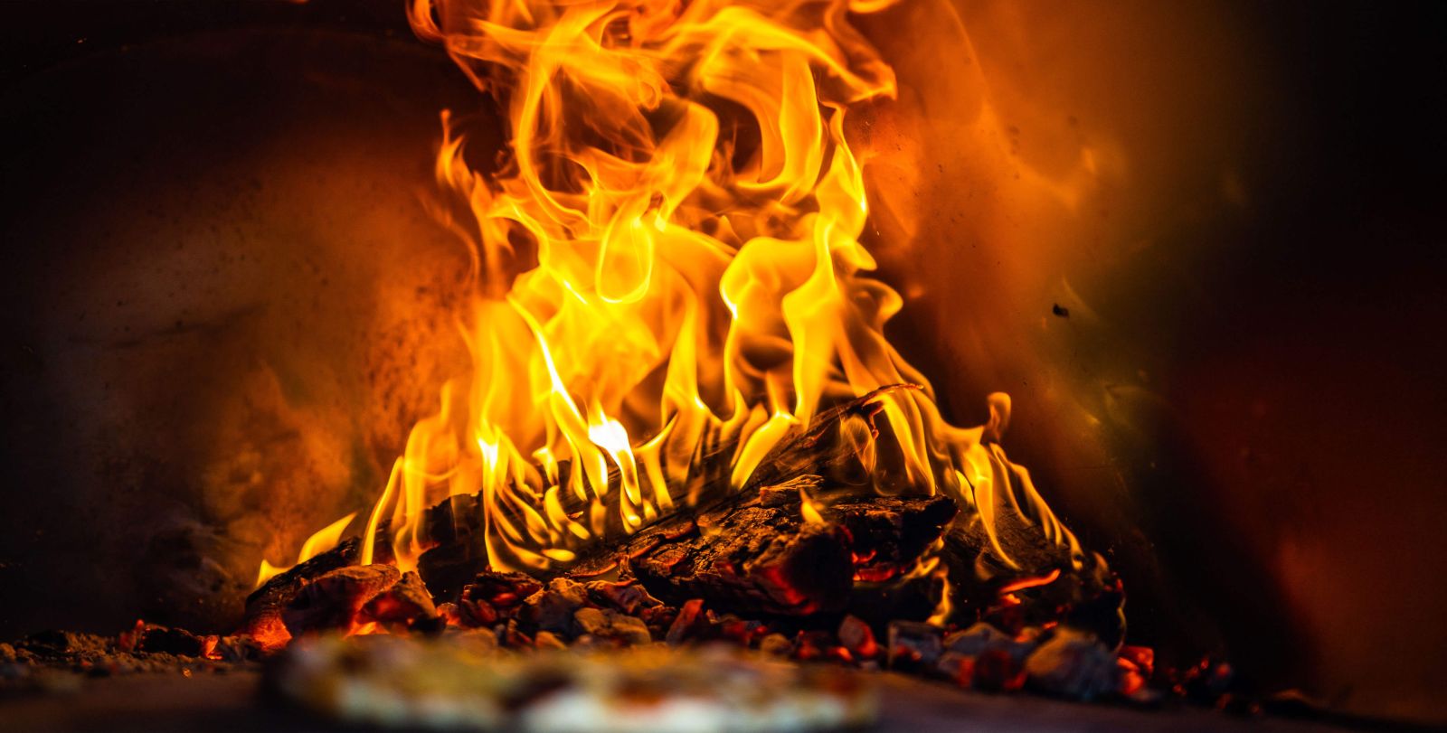 This image shows a pizza being cooked on hot surface of pizza oven