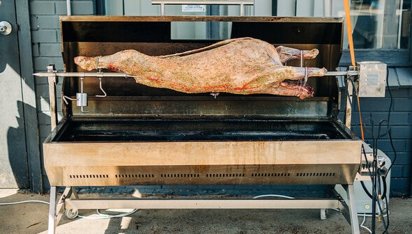 Whole lamb mounted on spit rotisserie BBQ ready for cooking