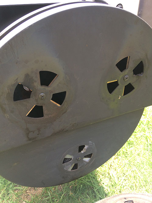 This picture shows the pin wheel dampers on the side of a firebox of an offset smoker