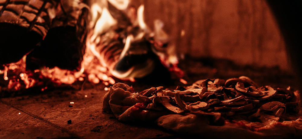 Cooking pizza inside the pizza oven (Photo by Arthur Brognoli from Pexels)