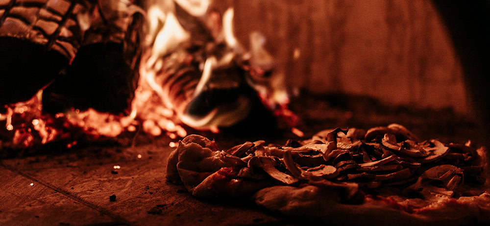 Cooking pizza inside the pizza oven (Photo by Arthur Brognoli from Pexels)